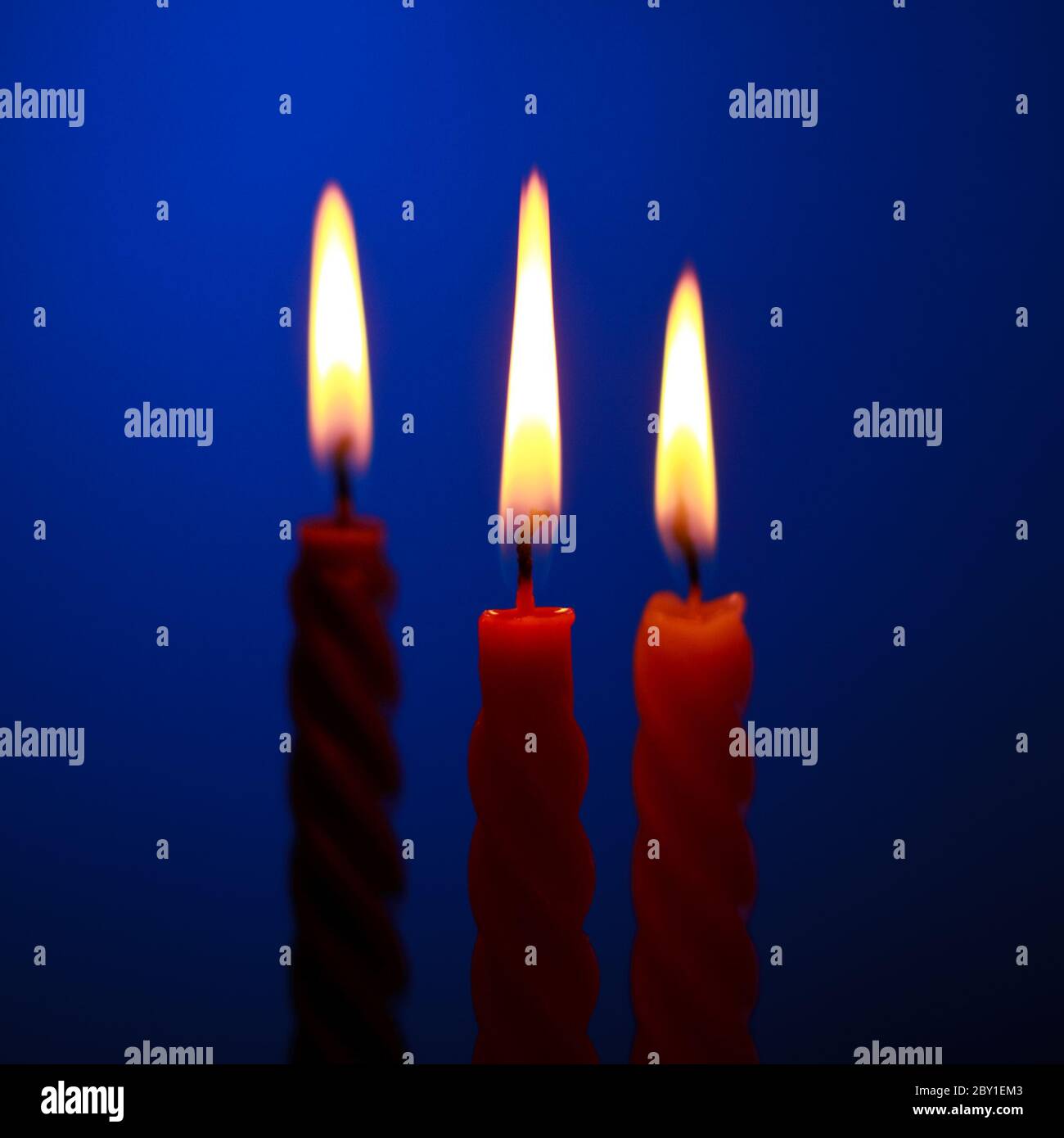 Drei Kerzen auf blau Stockfoto