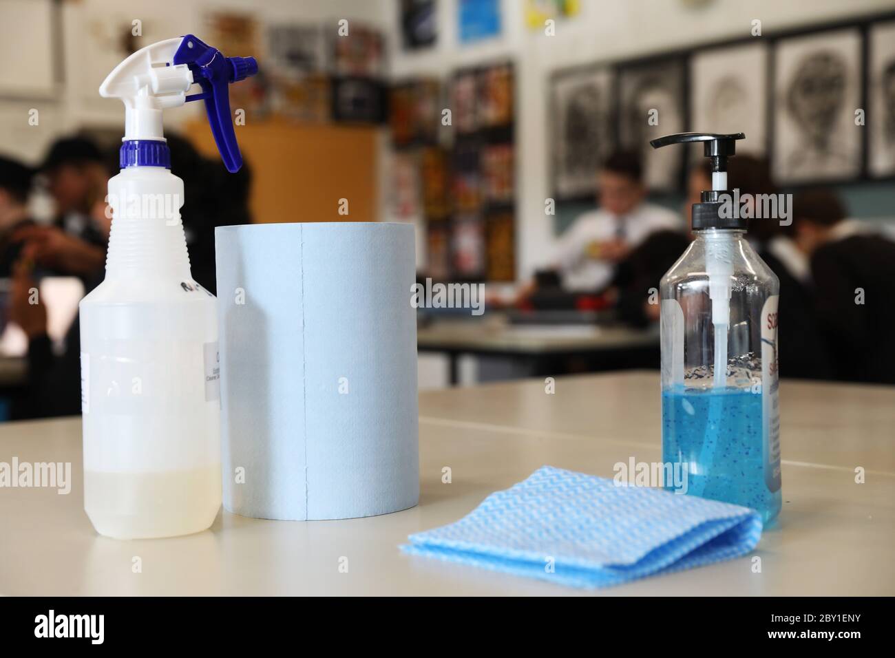 Eine Anordnung von Desinfektionsmittel und Desinfektionsmittel für Handsantizer auf einem Tisch in einem Klassenzimmer. Neue Schule Bildungseinrichtung sichere Hygiene Praktiken durch CO Stockfoto