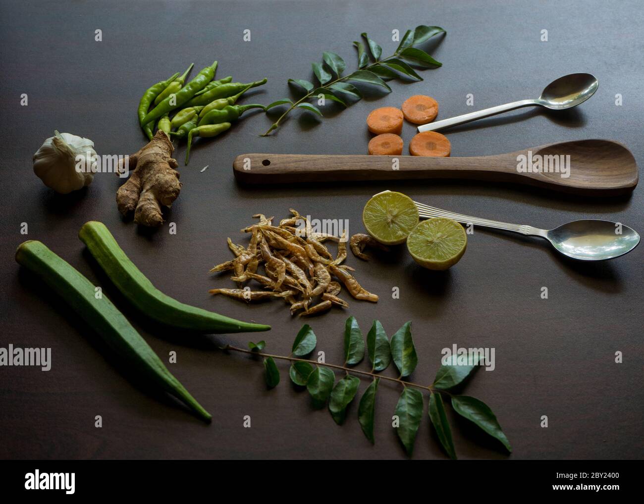 Schön garniert Lebensmittel Zutaten auf der Tischplatte gehören verschiedene Gewürze wie kühl, Zitrone, Curry Blätter, Ingwer, Knoblauch, Garnelen, Löffel etc. Stockfoto