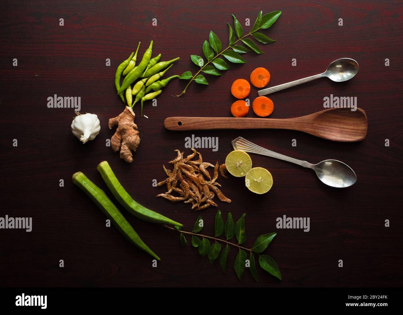 Schön garniert Lebensmittel Zutaten auf der Tischplatte gehören verschiedene Gewürze wie kühl, Zitrone, Curry Blätter, Ingwer, Knoblauch, Garnelen, Löffel etc. Stockfoto
