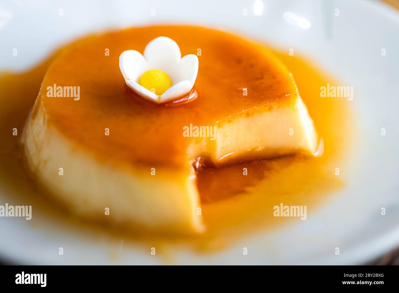 Nahaufnahme von hausgemachtem Karamell-Pudding auf weißem Teller mit selektivem Fokus Stockfoto