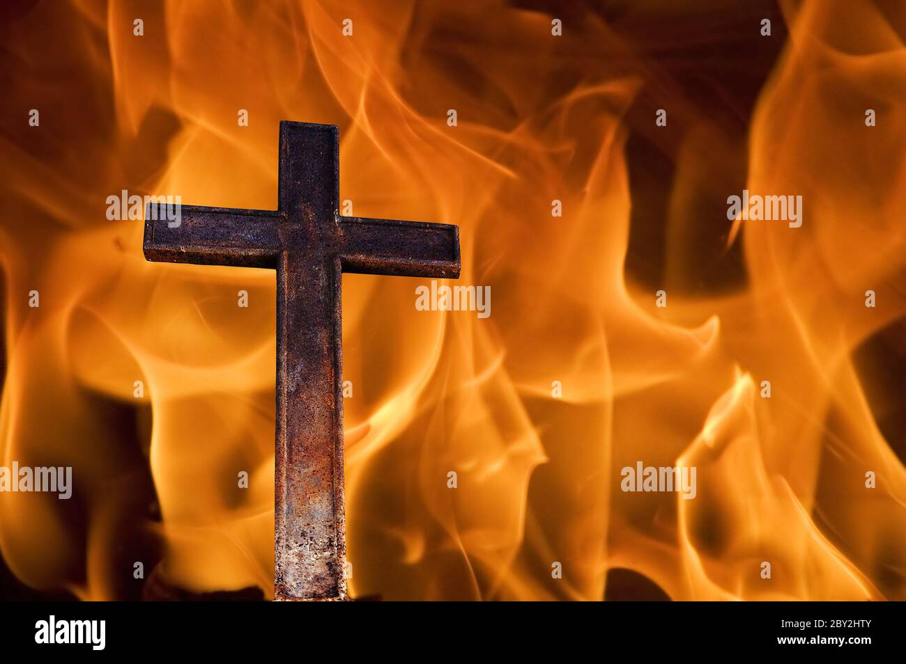Kreuz auf Feuer Stockfoto