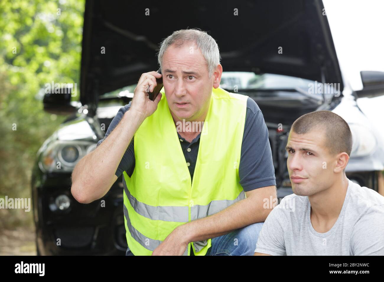 Vater und junger Mann mit Panne Auto Stockfoto