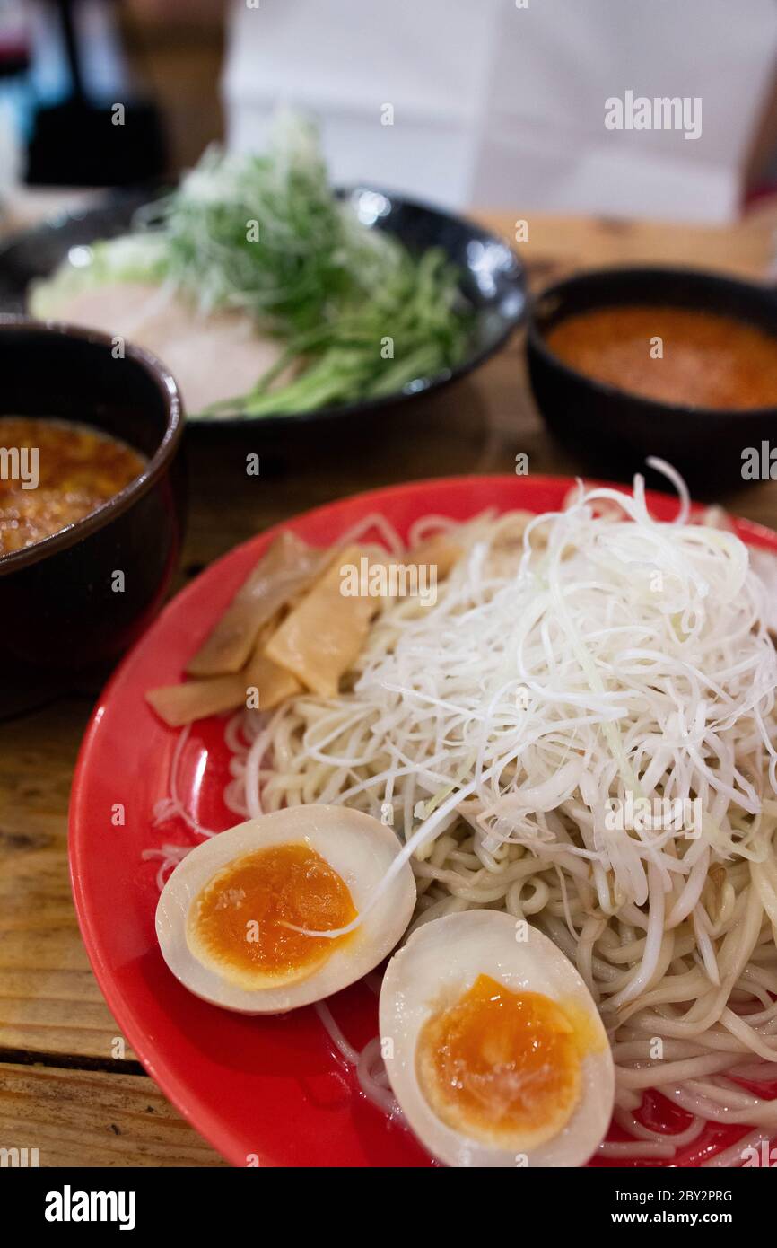 Japanische Hiroshima traditionelle Brühe Ramen Nudeln mit weich gekochten Eiern auf dem Holztisch serviert Stockfoto