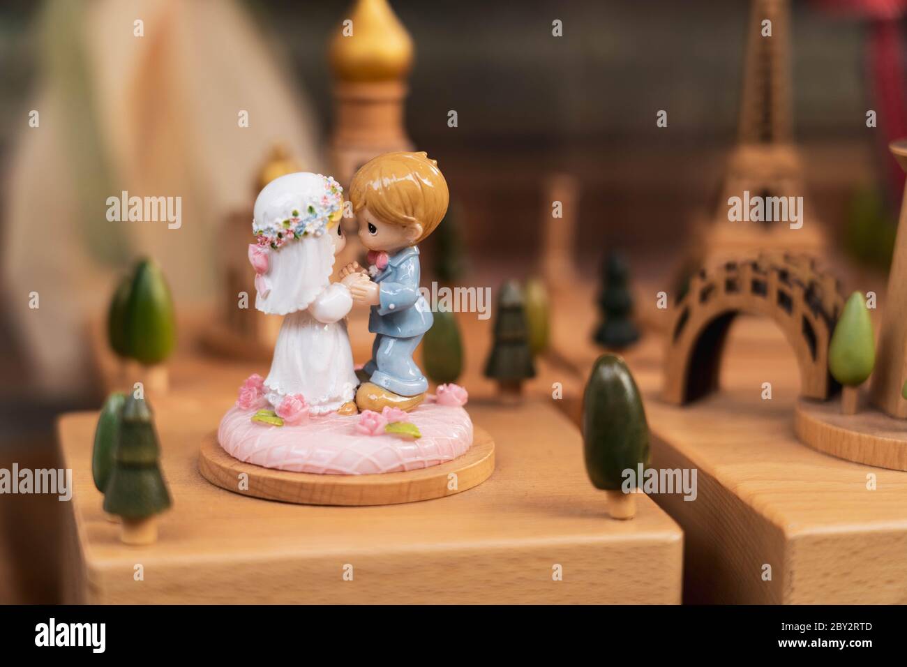 Braut und Bräutigam Miniaturstatue auf einem Holzständer. Romantische Paar Miniatur Figuren Dekoration. Stockfoto
