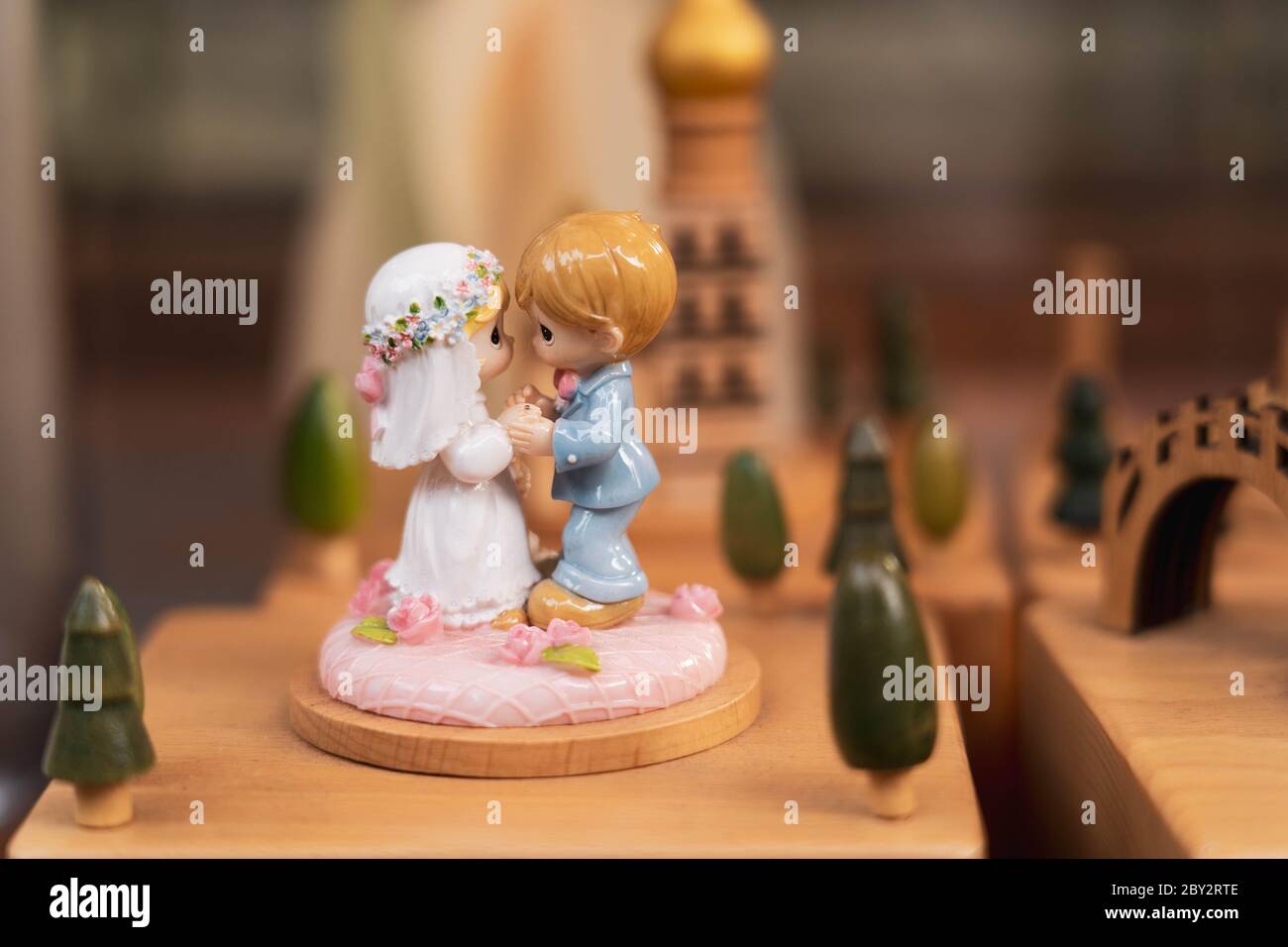 Braut und Bräutigam Miniaturfiguren auf einem Holzständer. Romantisches Paar Miniatur-Statue und Skulpturen Dekoration. Stockfoto