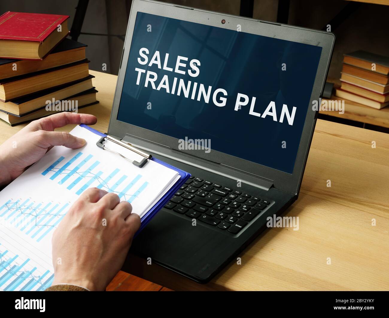 Manager liest den Sales Training Plan auf dem Laptop. Stockfoto