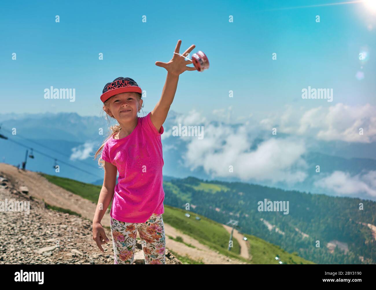Mädchen spielt mit Jo-Jo in den Bergen Stockfoto