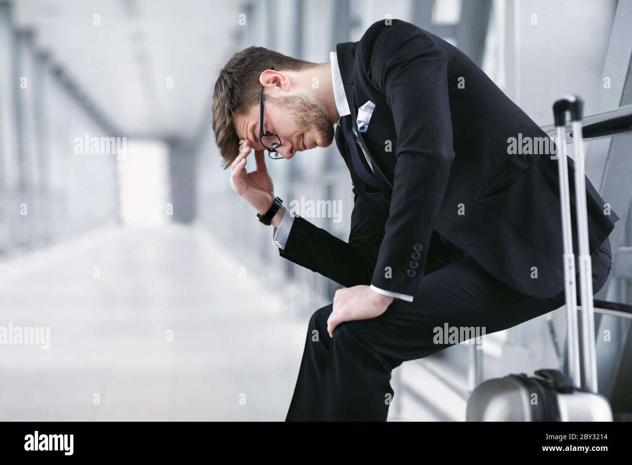 Trauriger urbaner Geschäftsmann sitzt auf dem Flughafen Stockfoto