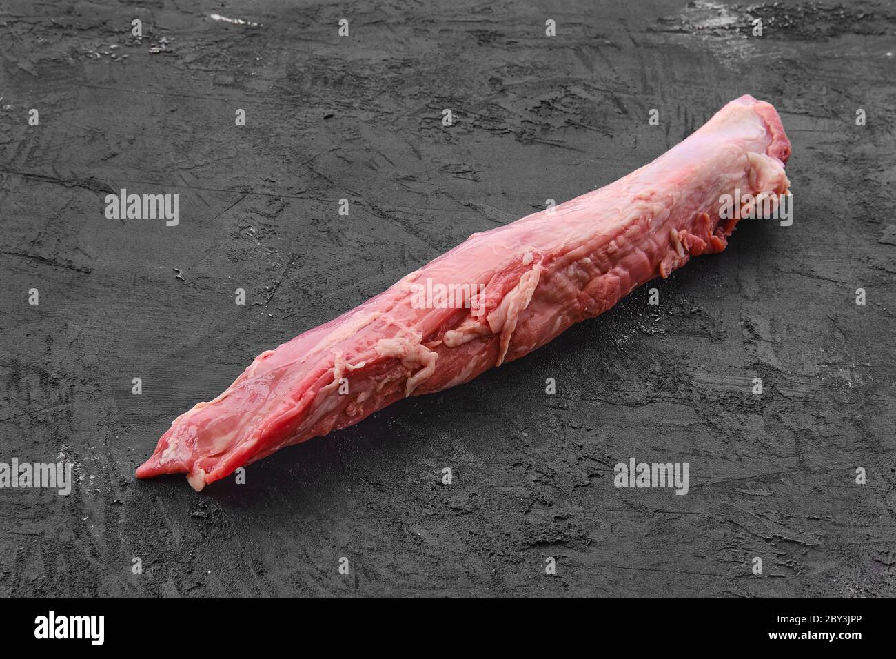 Rohes frisches Schweinefilet auf schwarzem Hintergrund Stockfoto