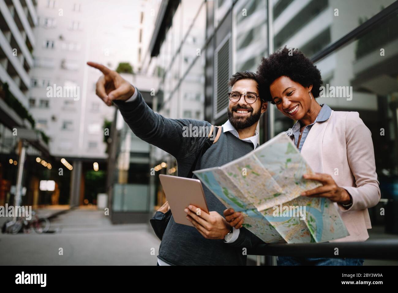 Verlorenes glückliches Paar in der Stadt, das eine Karte hält. Reisen, Tourismus, Menschen Konzept Stockfoto