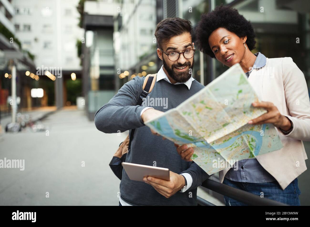 Verlorenes glückliches Paar in der Stadt, das eine Karte hält. Reisen, Tourismus, Menschen Konzept Stockfoto