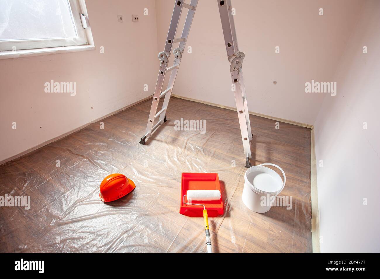 Malwerkzeuge Walze Tablett Leiter und weiße Farbe in für das Malen vorbereitet leeren kleinen Raum Stockfoto