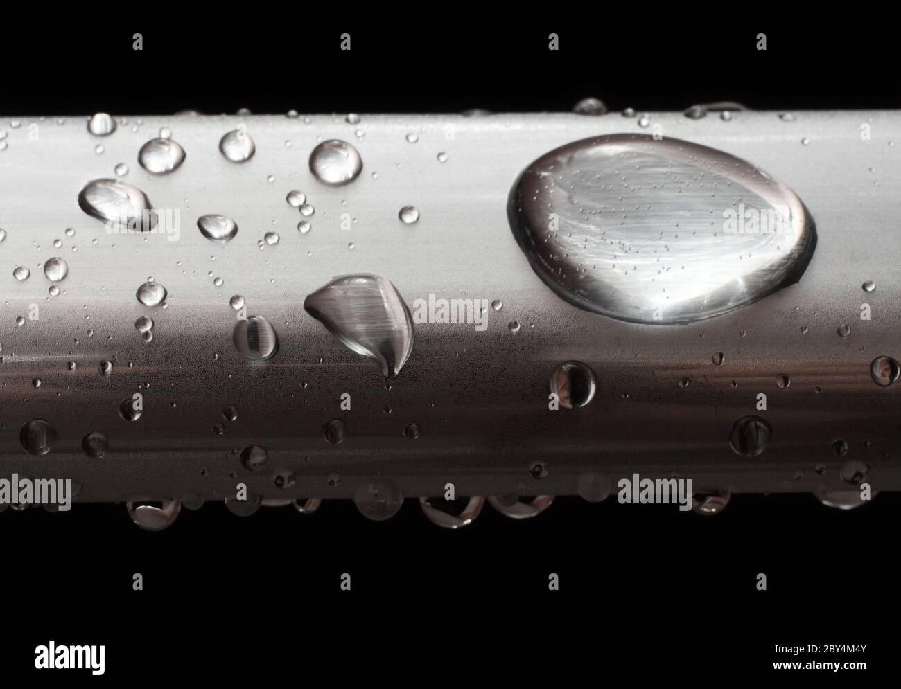 Wassertropfen auf vermischte Metallrohre Stockfoto