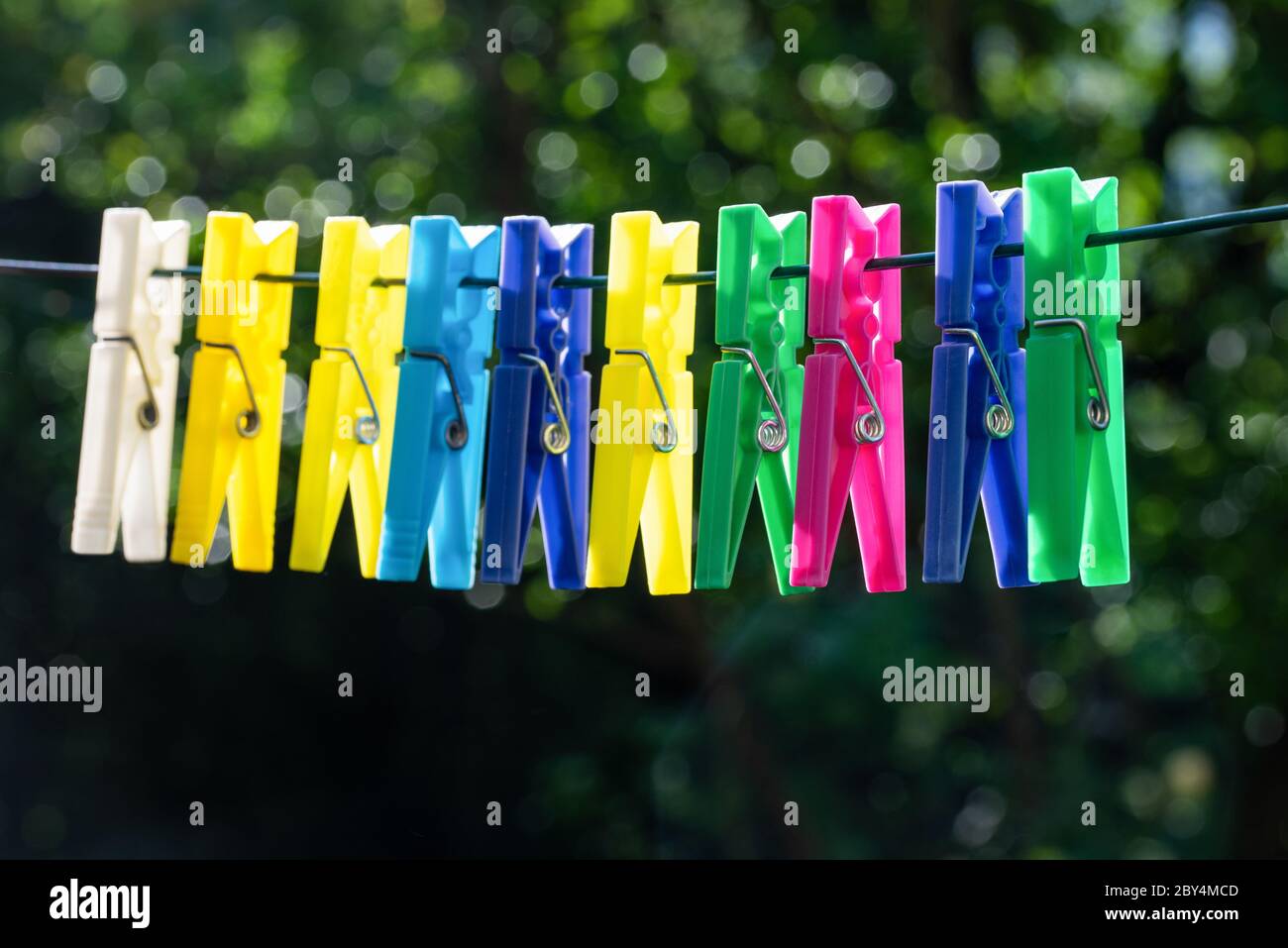 Gruppe von mehrfarbigen Wäscheklammern, die an einem Seil hängen Stockfoto