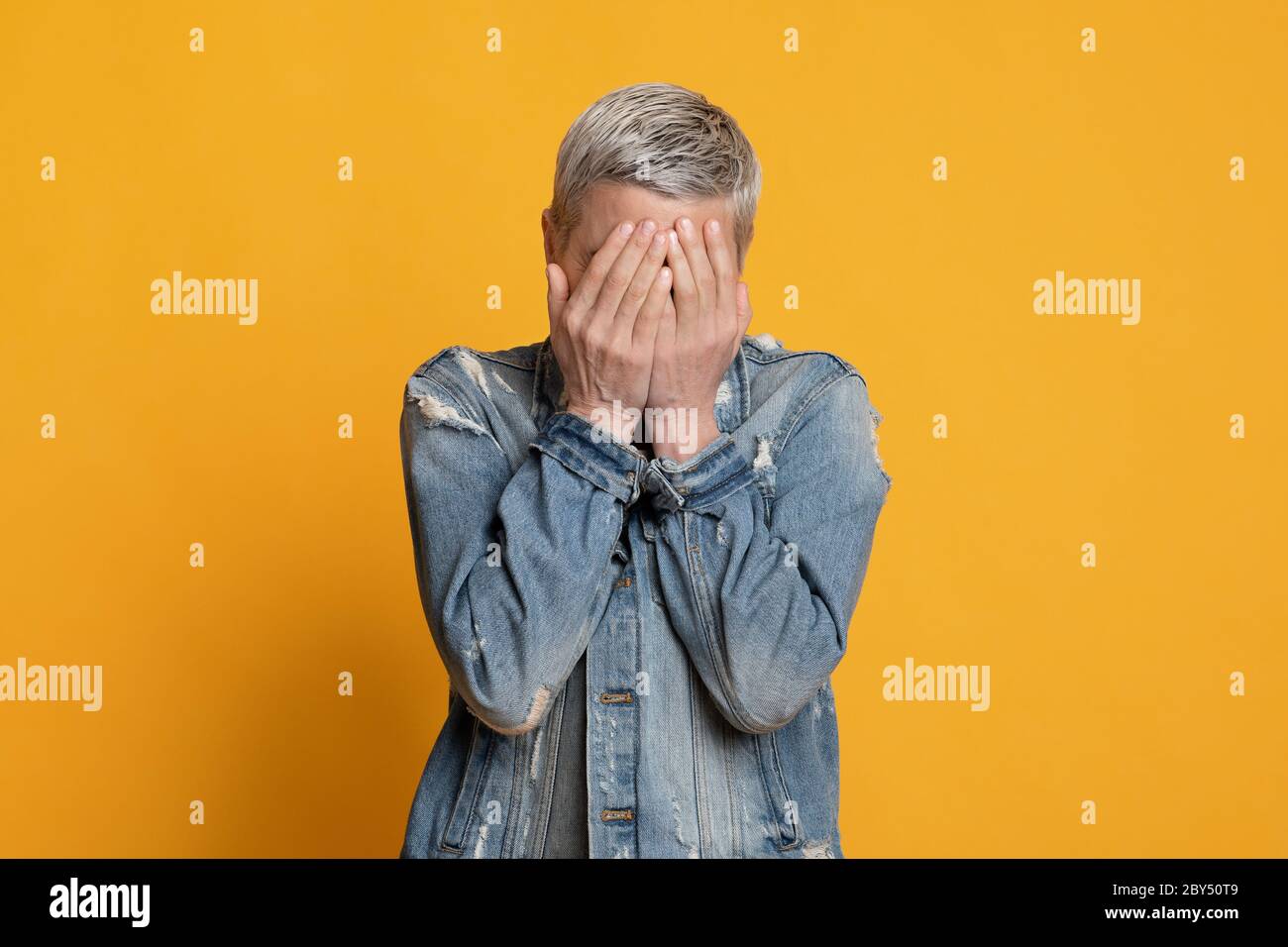 Sehen Sie kein böses Konzept. Erschrocken reife Dame bedeckt Gesicht mit Händen Stockfoto