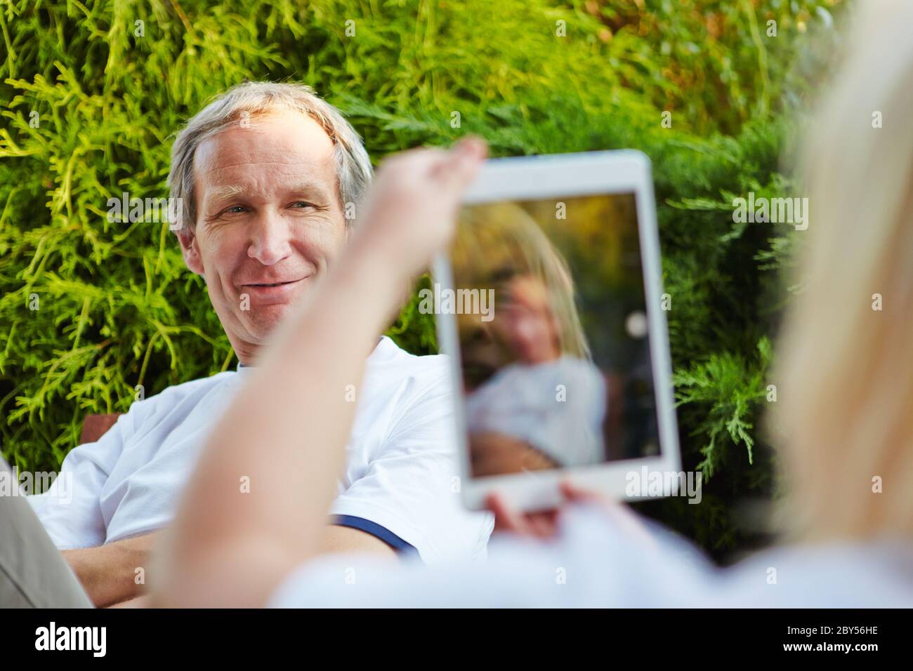 Ältere Paare im Urlaub mit Fotos mit Tablet-Computer von sich selbst. Stockfoto