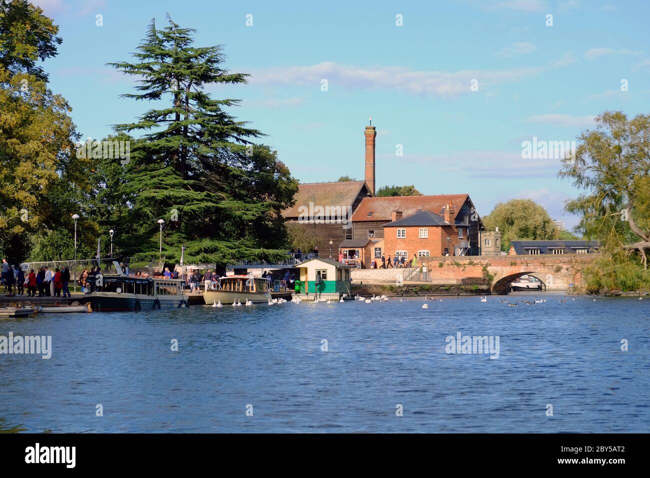 Blick über den Fluss Avon zu den Bancroft Gardens, Flussbootkreuzfahrtschiffen und Cox's Yard, in Stratford-upon-Avon, England, Großbritannien Stockfoto