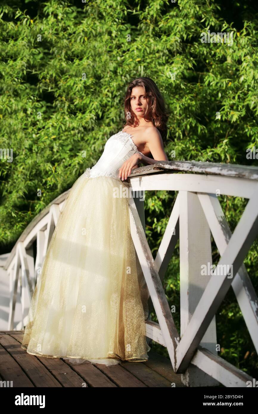 Schöne Braut auf der Holzbrücke Stockfoto