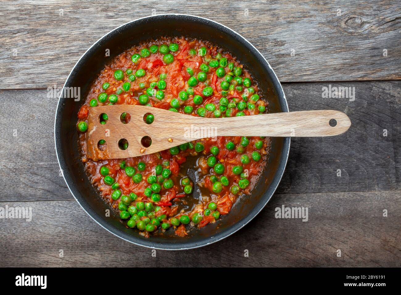 Studioaufnahme von grünen Bohnen in Tomatensauce auf verfallenem Holzhintergrund Stockfoto