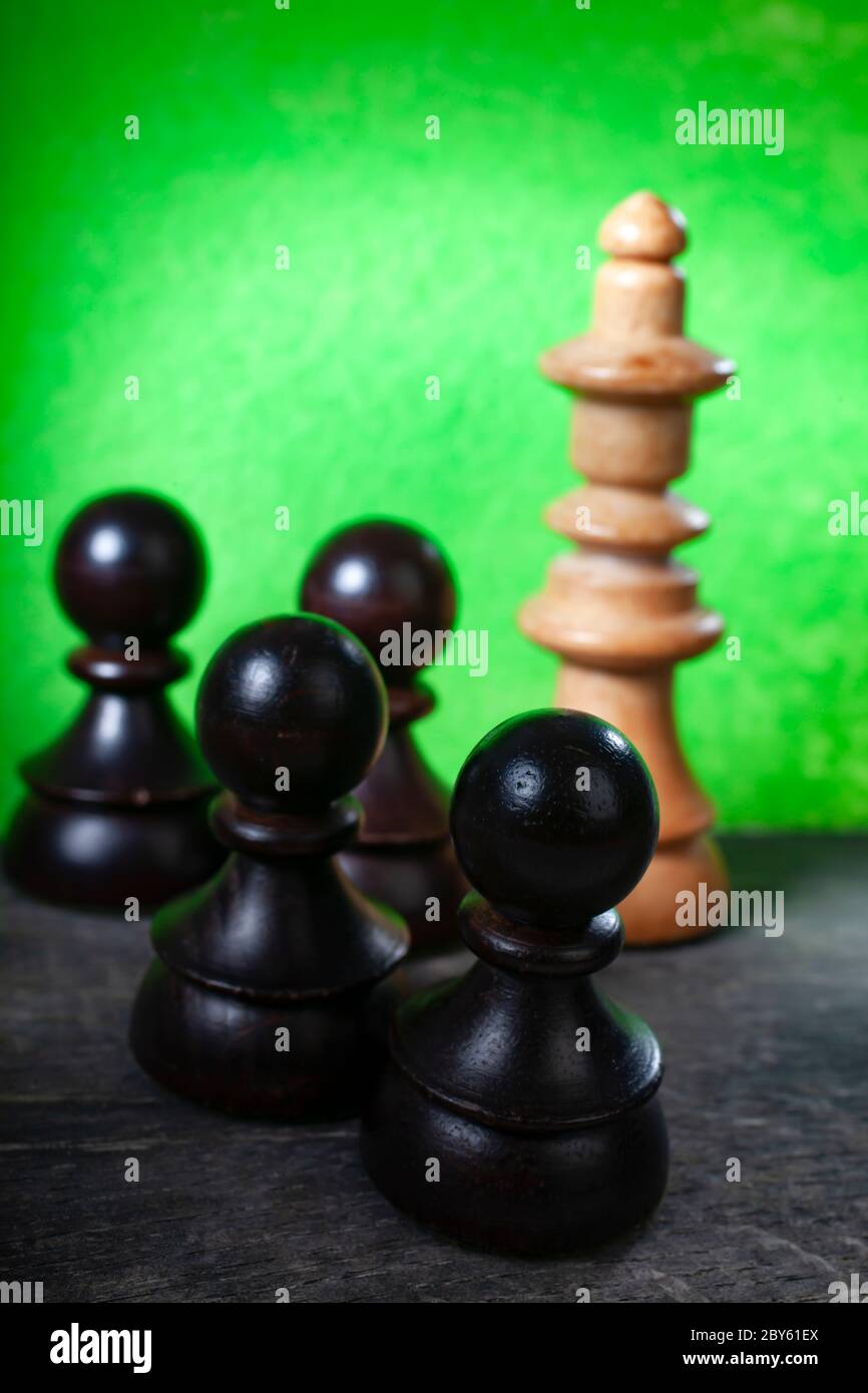 Makro-selektiver Fokus Foto von schwarzen Schachfiguren auf grünem Hintergrund Stockfoto