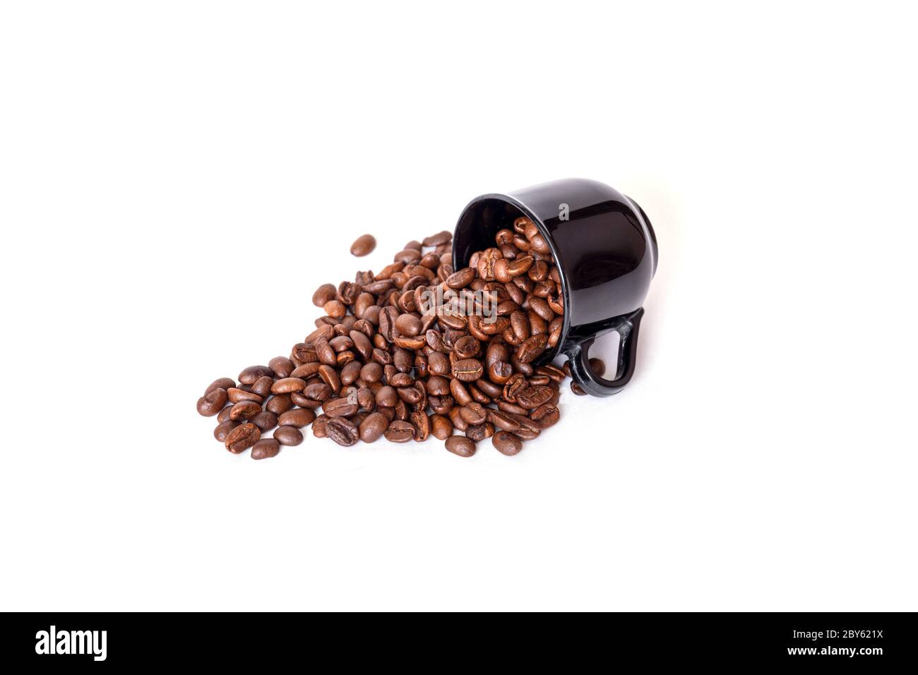 Verschüttete Kaffeebohnen aus der schwarzen Keramikschale isoliert auf weißem Hintergrund. Ideal für Kaffee-Menü. Stockfoto