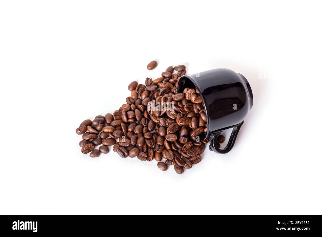 Verschüttete Kaffeebohnen aus der schwarzen Keramikschale isoliert auf weißem Hintergrund. Ideal für Kaffee-Menü. Stockfoto