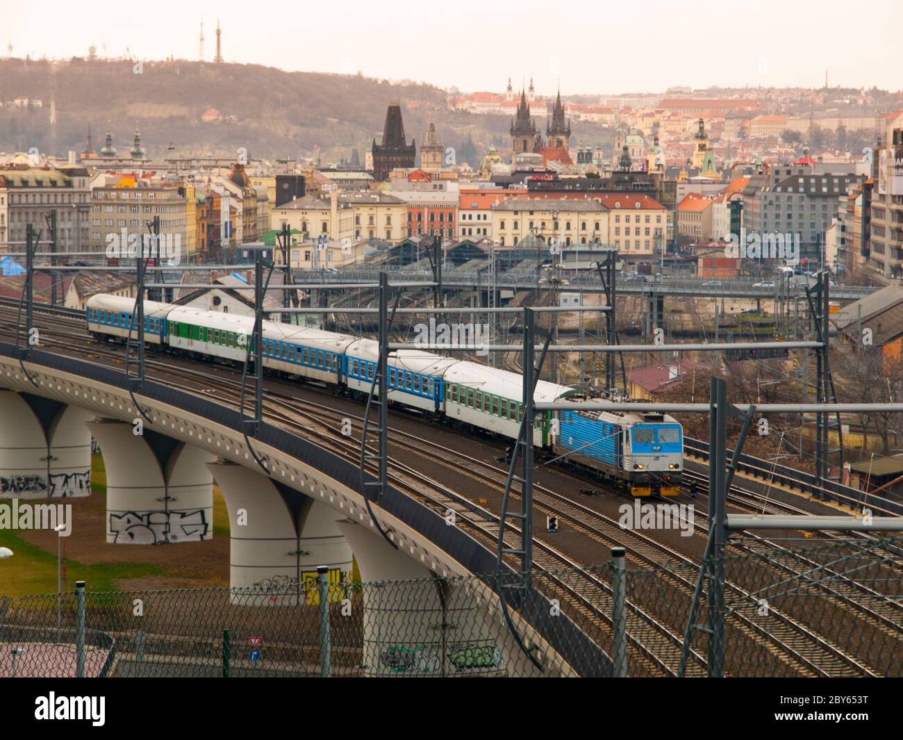 Zug verlässt Prag Hauptbahnhof über neue Brücke mit Panorama des Stadtzentrums auf dem Hintergrund, Tschechische Republik Stockfoto