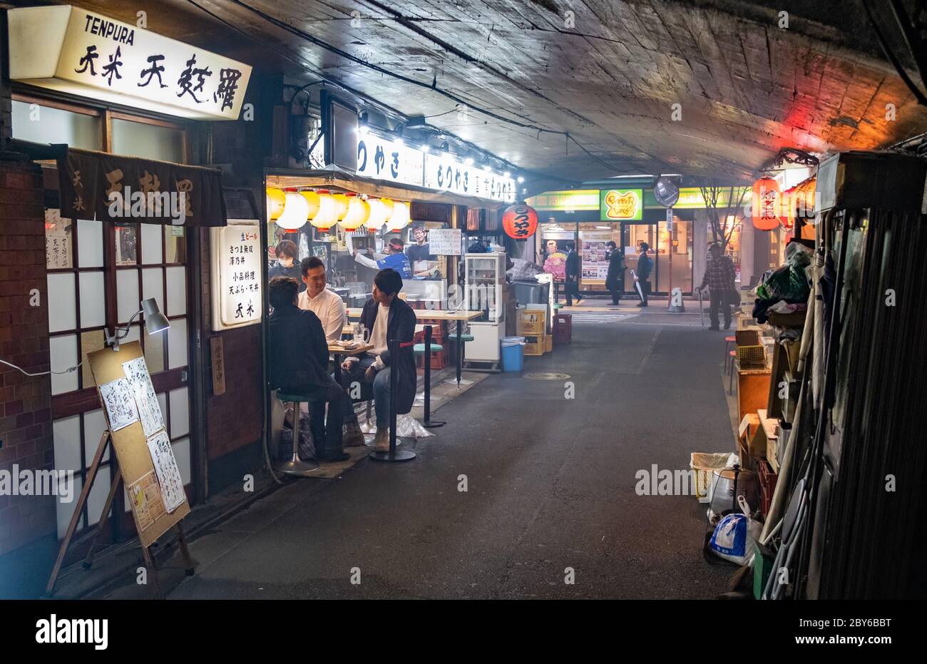 Leute, die in der Hintergasse des Yurakucho-Bezirks, Tokio, Japan bei Nacht spazieren gehen. Stockfoto
