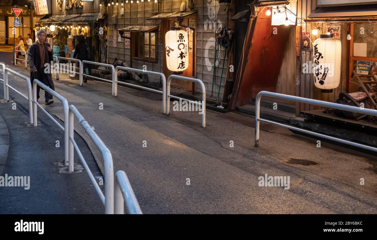 Leute, die in der Hintergasse des Yurakucho-Bezirks, Tokio, Japan bei Nacht spazieren gehen. Stockfoto