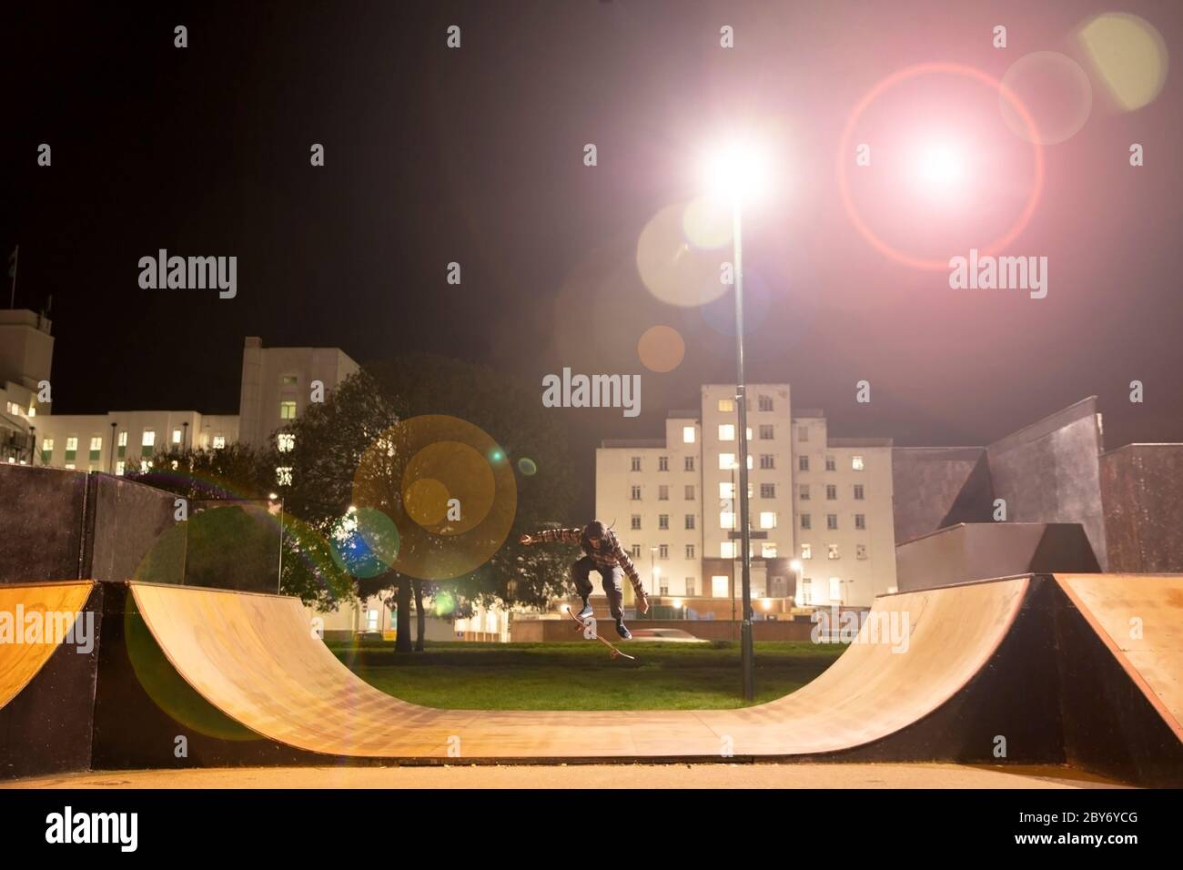 Junger Mann Skateboarding auf Skate Park Rampe in der Nacht Stockfoto