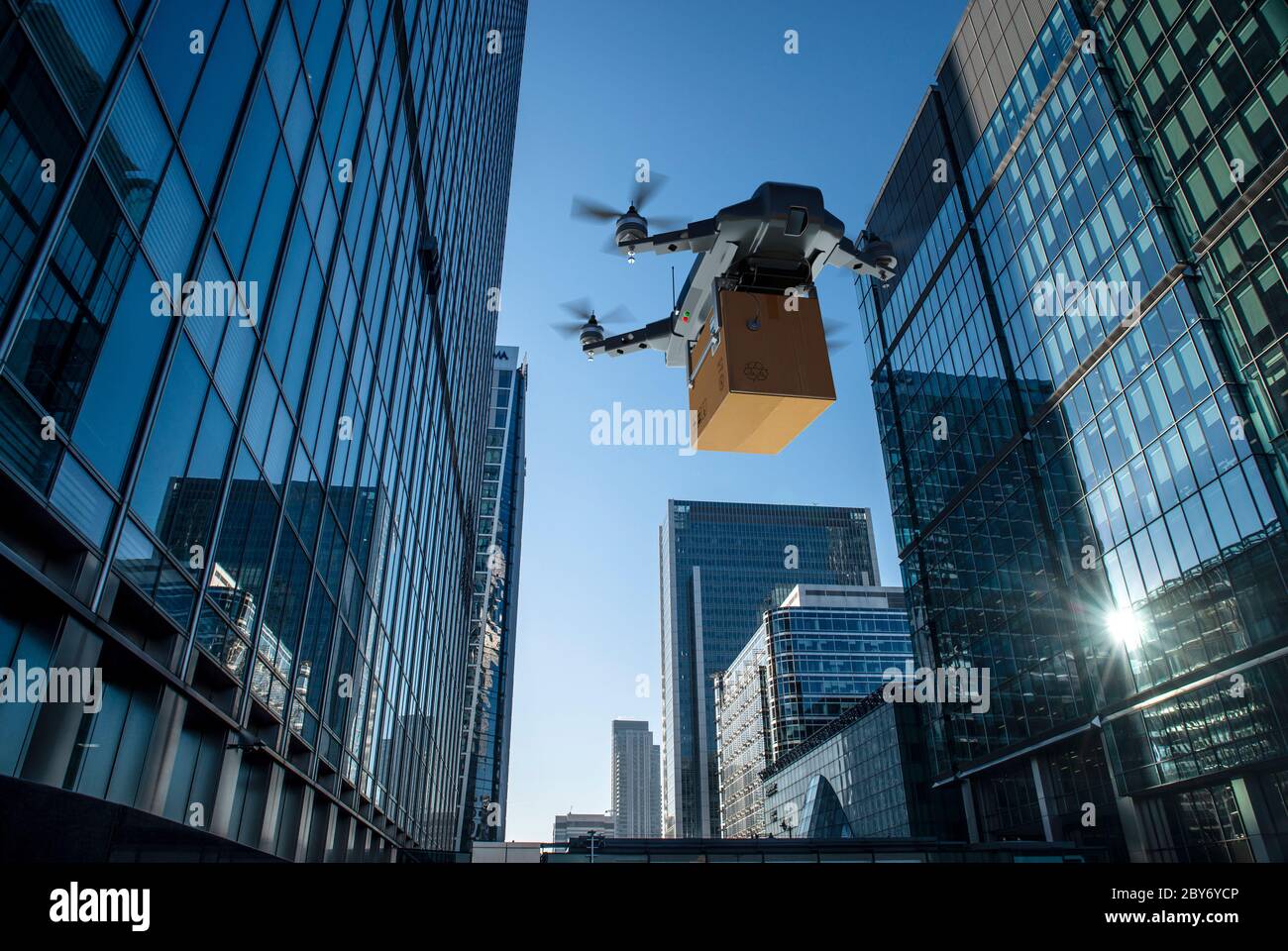 Drohne, die Paket zwischen Hochhäusern, London, Großbritannien Stockfoto