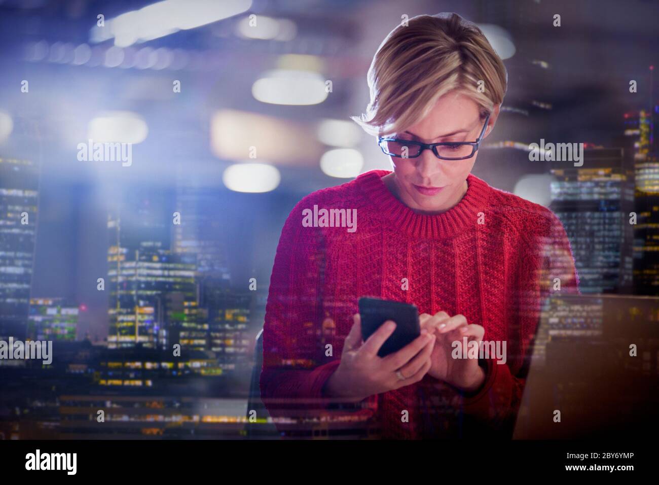 Geschäftsfrau mit Smartphone mit Stadtbild im Hintergrund Stockfoto