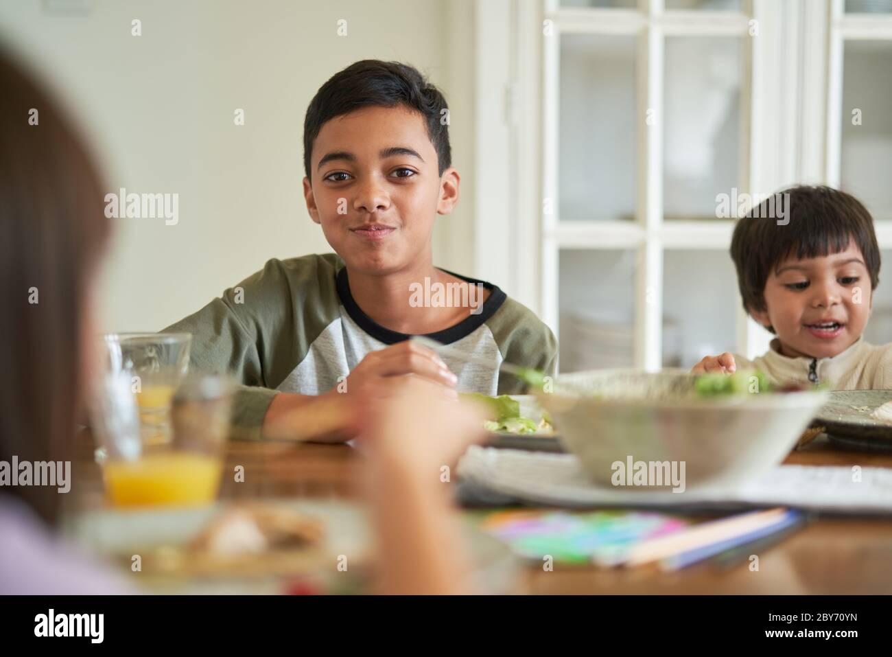 Portrait glücklich Junge essen Mittagessen mit Familie am Tisch Stockfoto