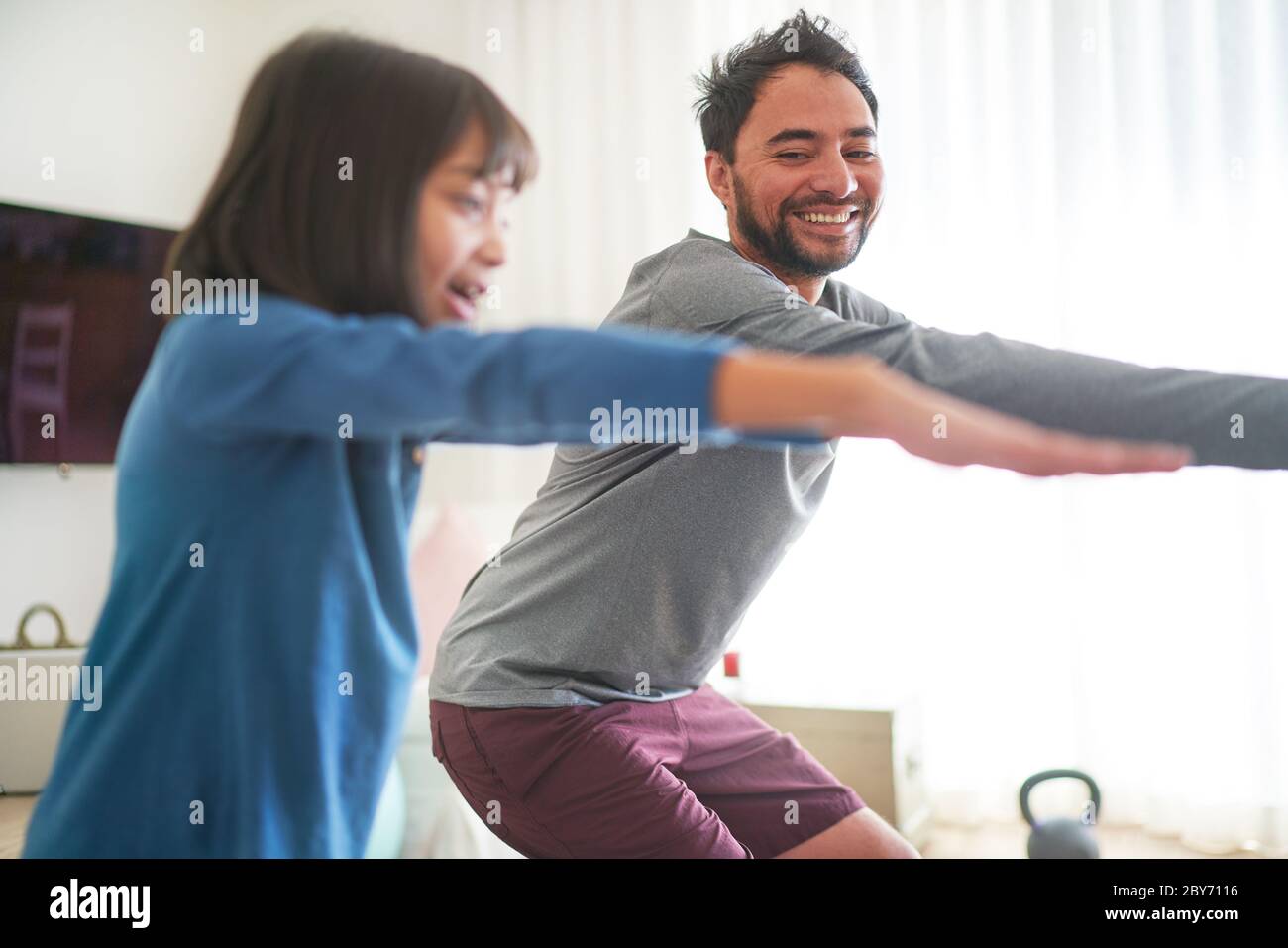 Glücklicher Vater und Tochter trainieren im Wohnzimmer Stockfoto