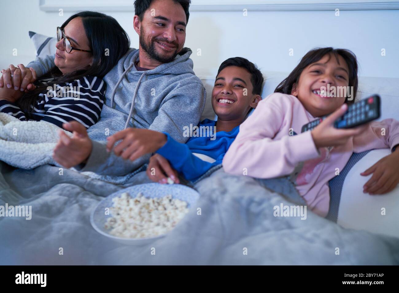 Familie vor dem Fernseher auf sofa Stockfoto