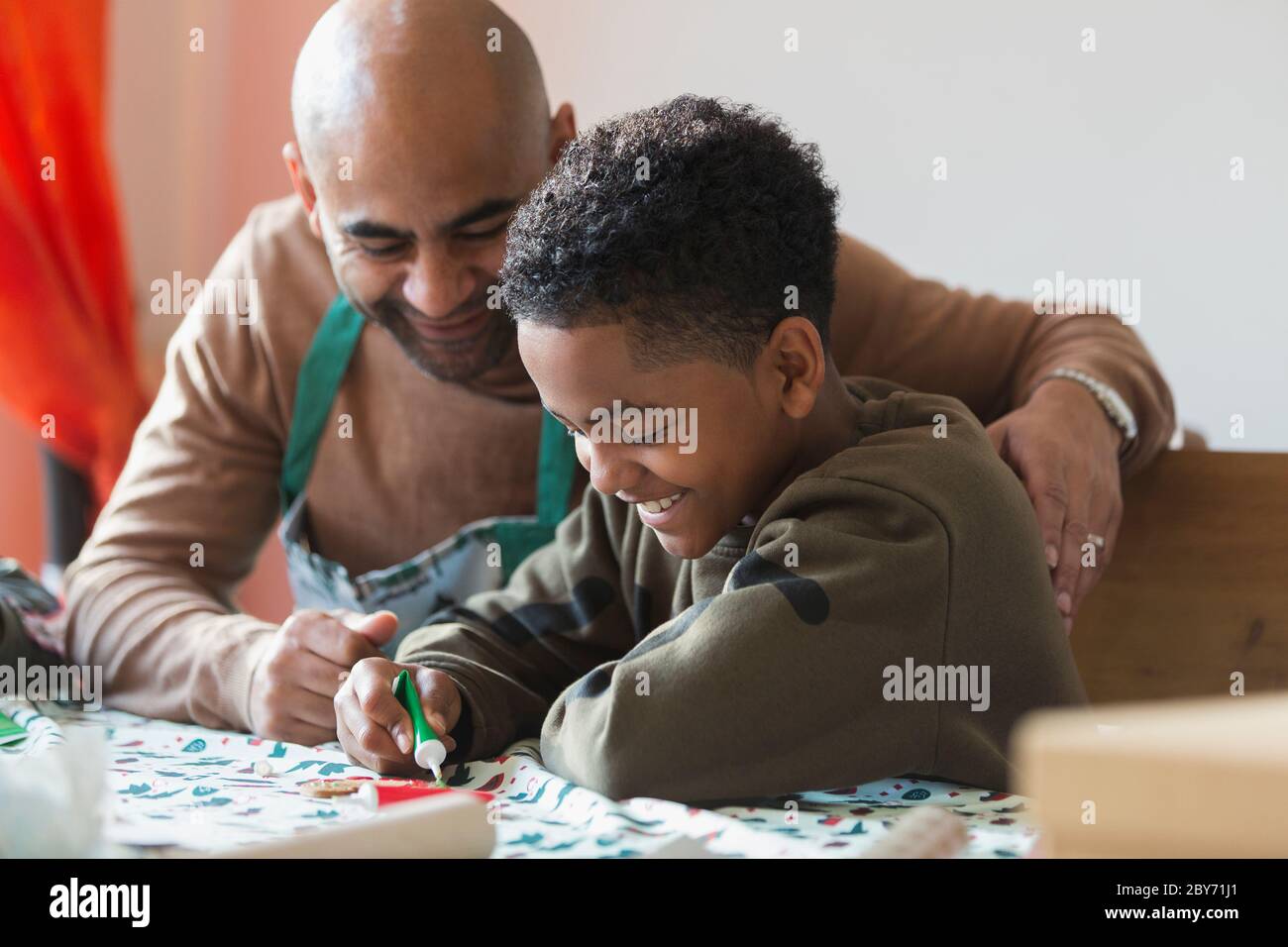 Glücklicher Vater und Sohn dekorieren Weihnachtskekse Stockfoto