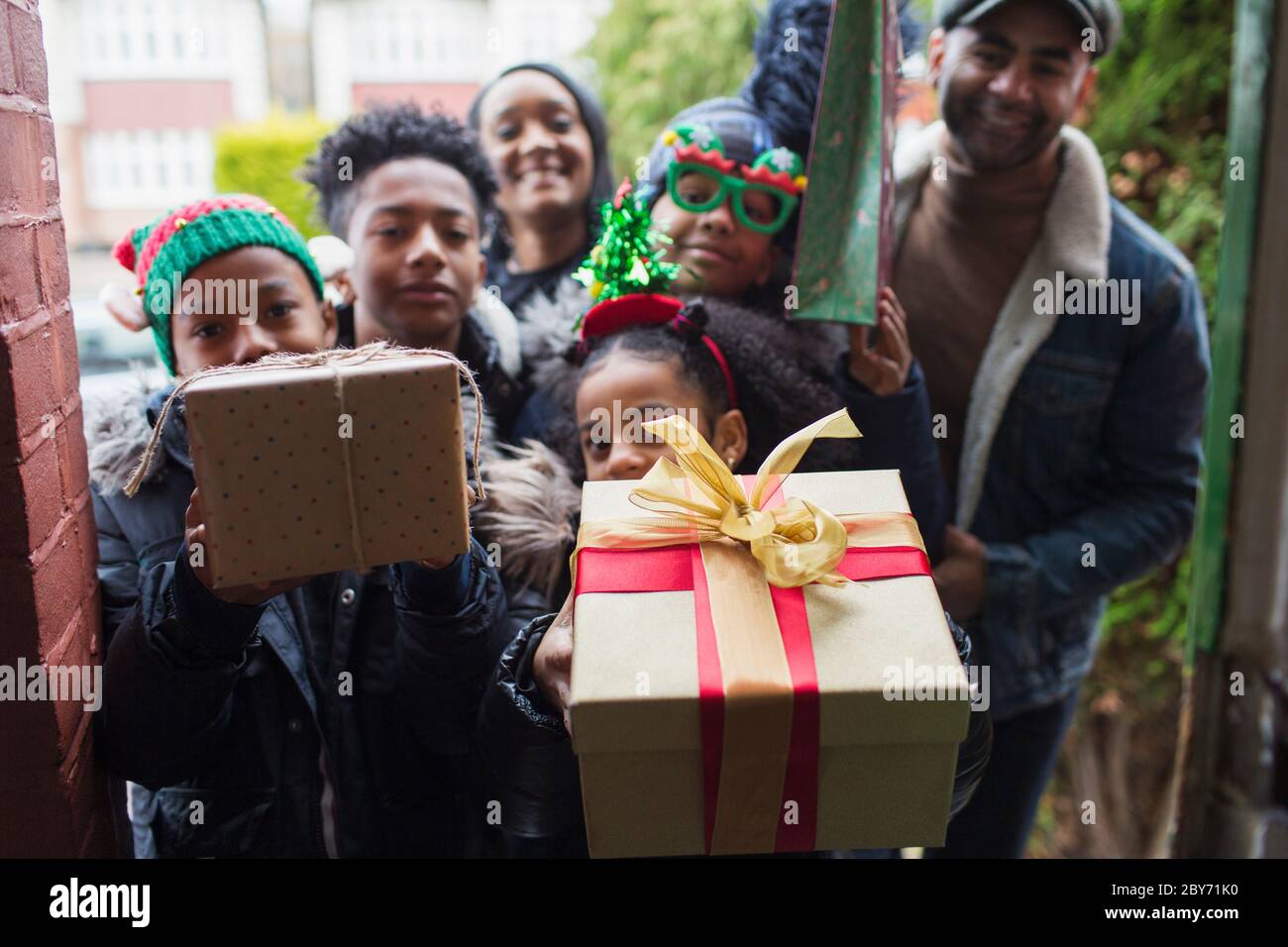 Portrait glückliche Familie Lieferung Weihnachtsgeschenke auf der Vorderseite stoop Stockfoto