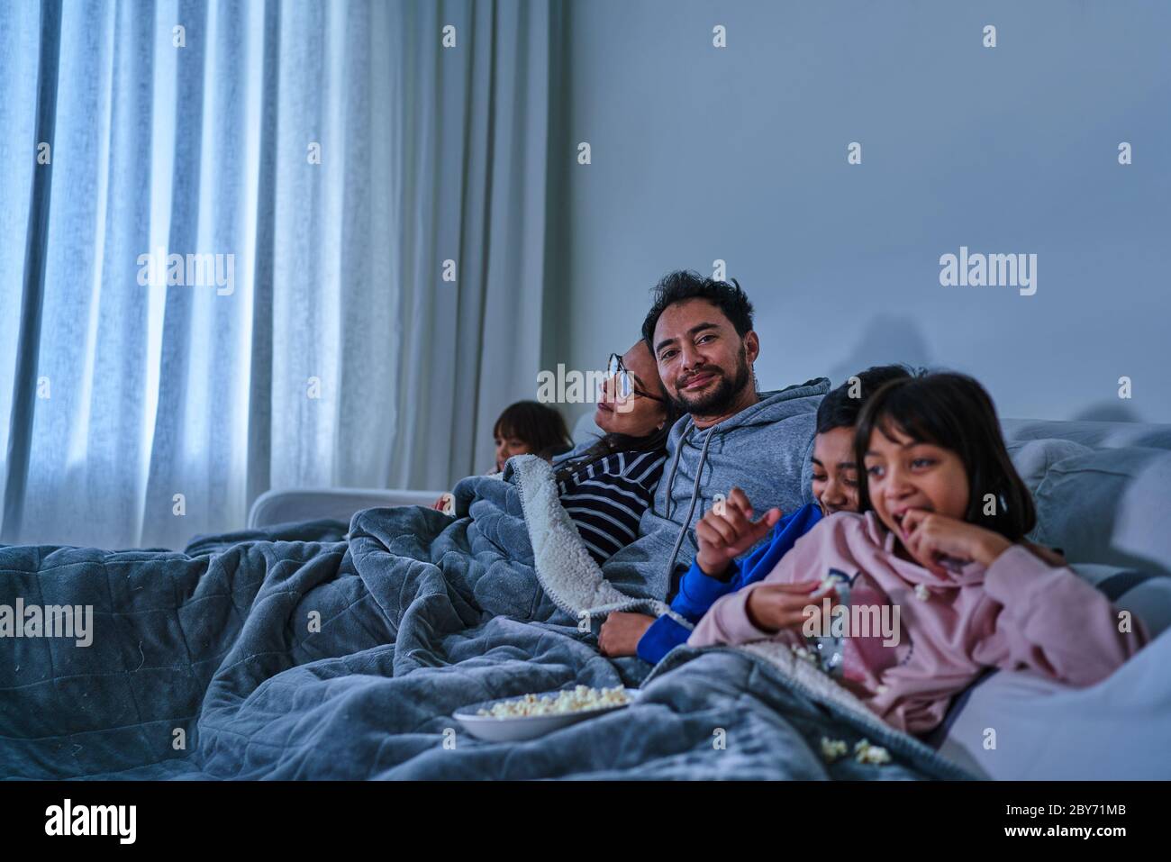 Portrait glücklicher Mann entspannend und Film mit Familie auf dem Sofa Stockfoto