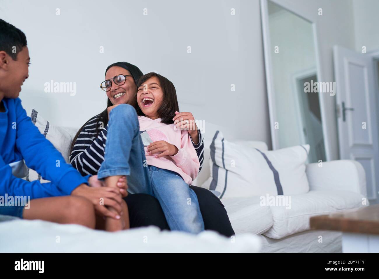 Glückliche Familie auf Wohnzimmer Sofa Stockfoto