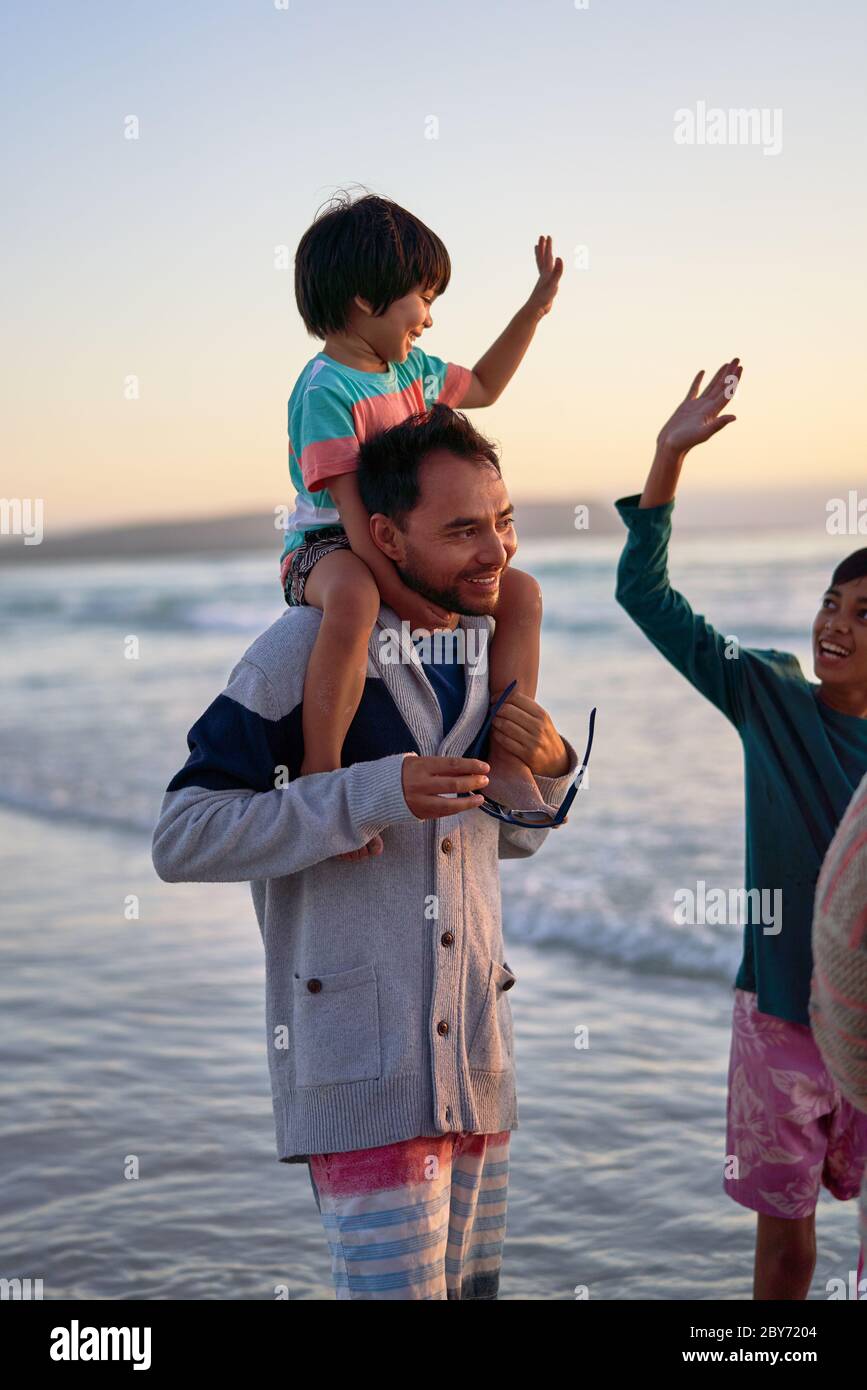 Glückliche Familie watend in Ozean surfen Stockfoto