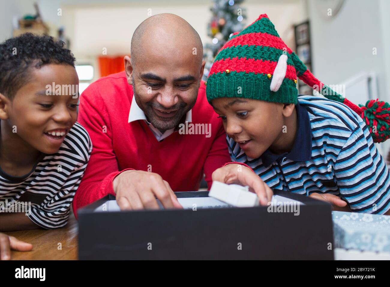 Vater und Söhne Eröffnung Weihnachtsgeschenk Stockfoto