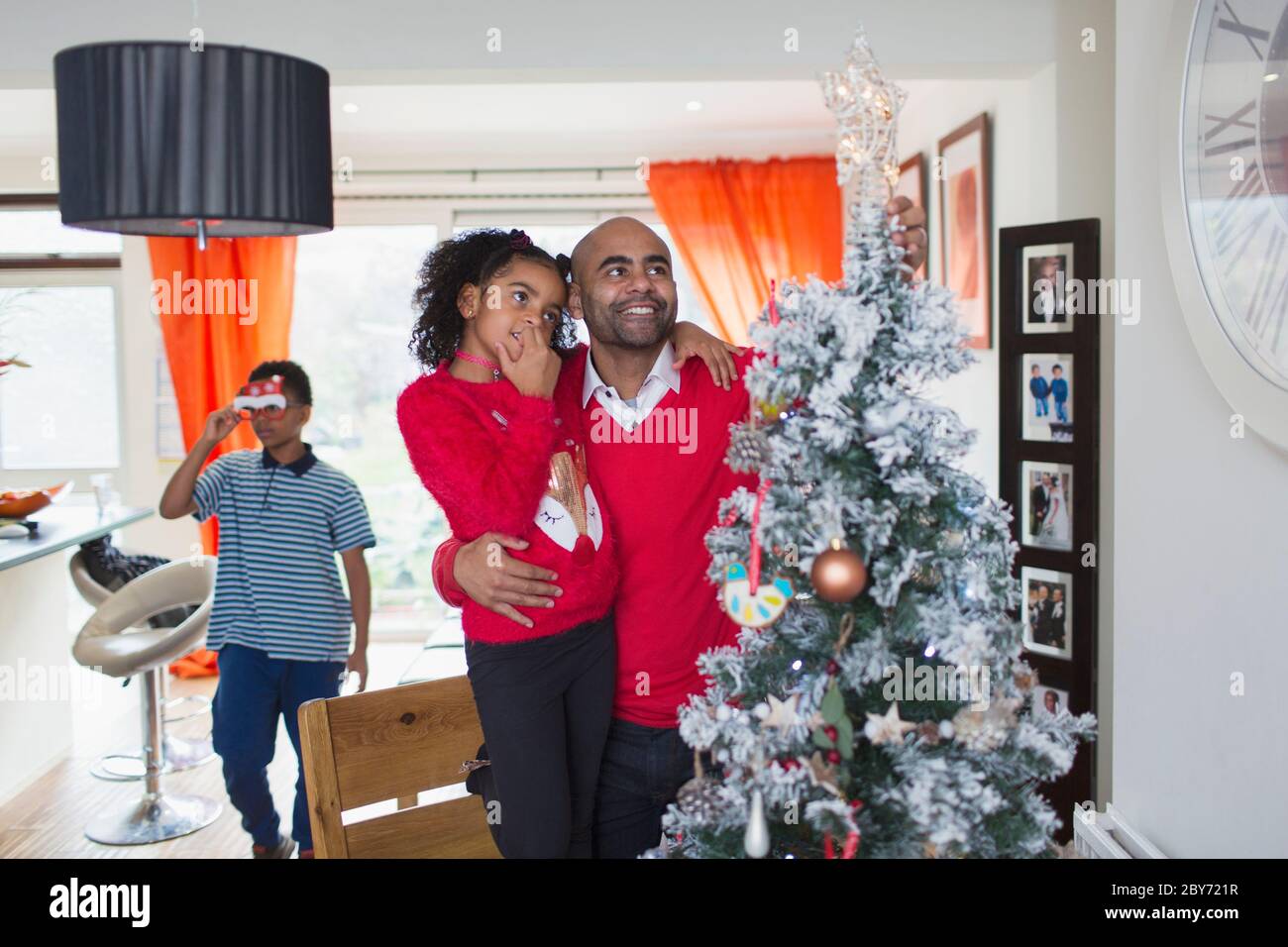 Vater und Tochter schauen auf den Weihnachtsbaum Stockfoto