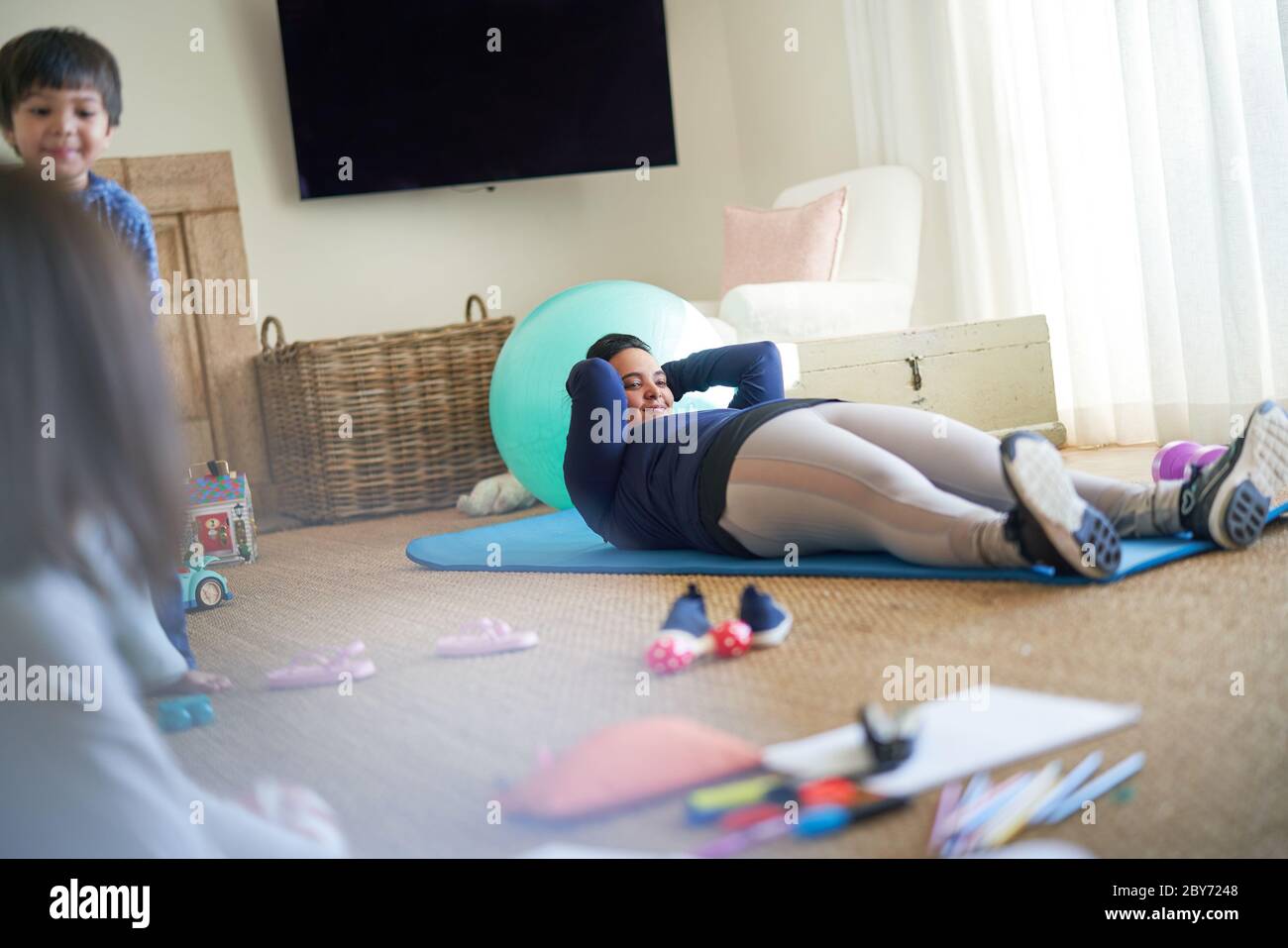 Mutter trainiert im Wohnzimmer mit Kindern Stockfoto