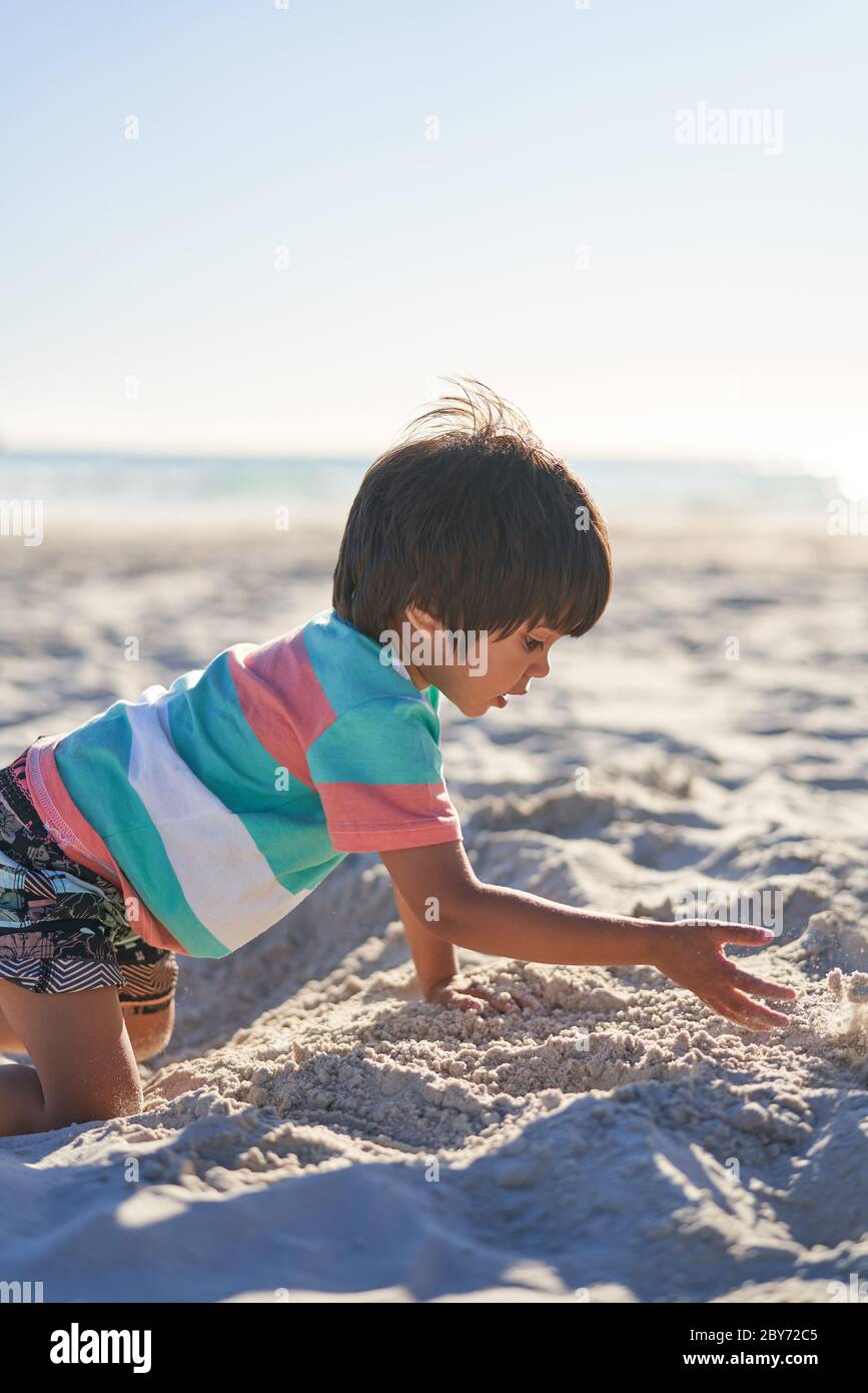 Junge spielt im Sand am sonnigen Sommerstrand Stockfoto