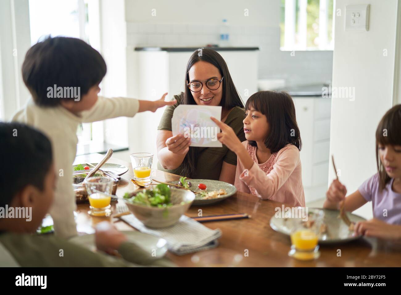 Mutter und Kinder essen am Esstisch zu Mittag Stockfoto