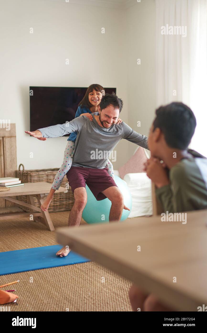 Spielerisch Vater und Tochter trainieren im Wohnzimmer Stockfoto