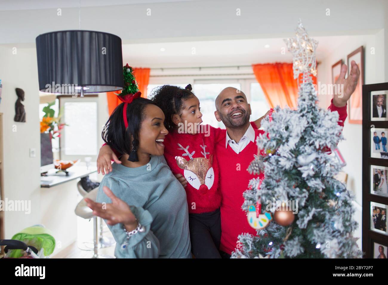 Happy Family schmücken Weihnachtsbaum im Wohnzimmer Stockfoto