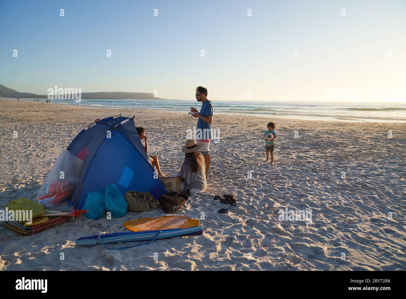 Familie entspannen und spielen im Zelt am Ocean Beach, Kapstadt Stockfoto