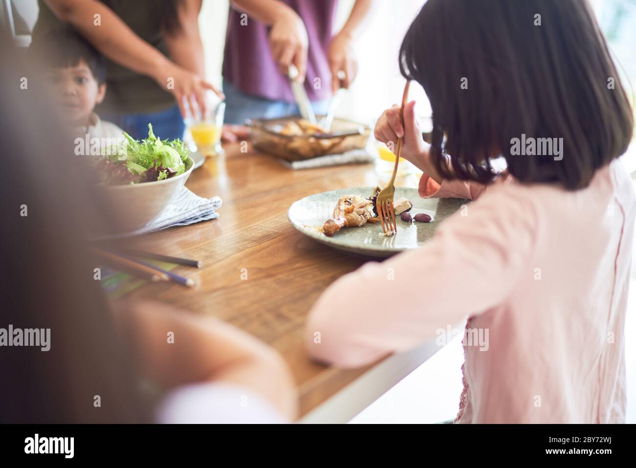 Mädchen essen Mittagessen am Esstisch Stockfoto